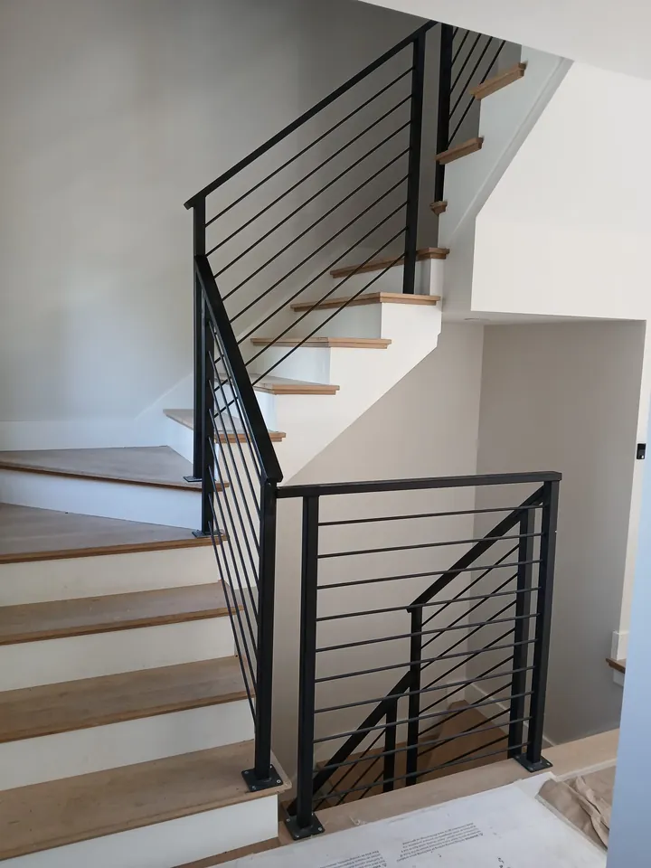 Black horizontal-bar interior stair railing installed by MetalArt