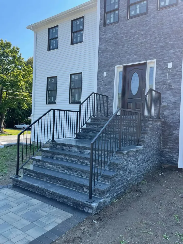 Black iron railings on bluestone front steps