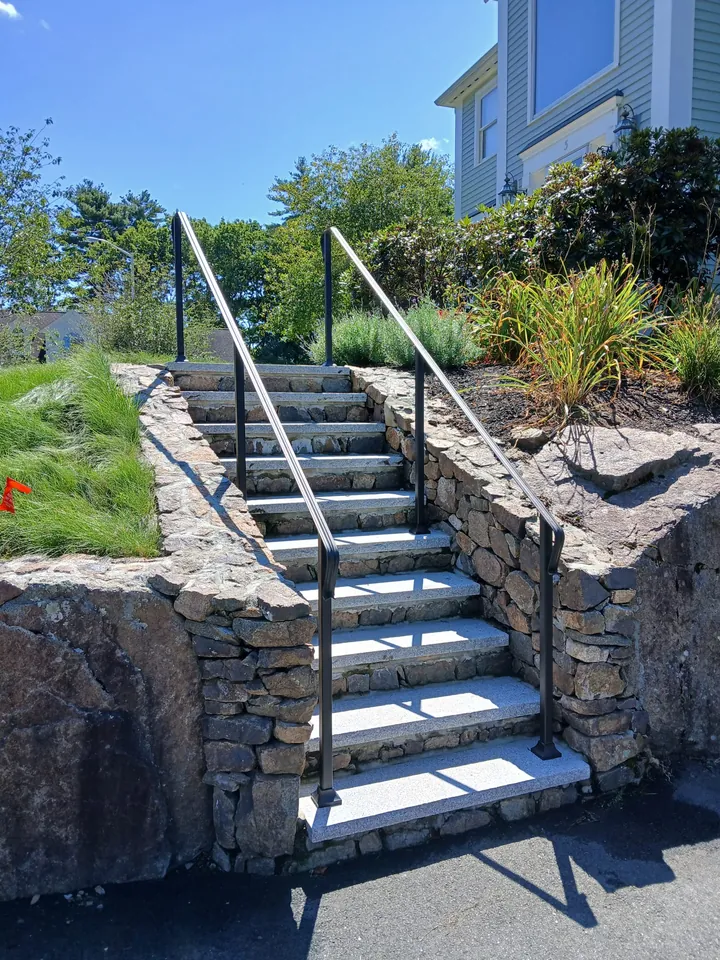 Pair of black handrails on stone garden steps